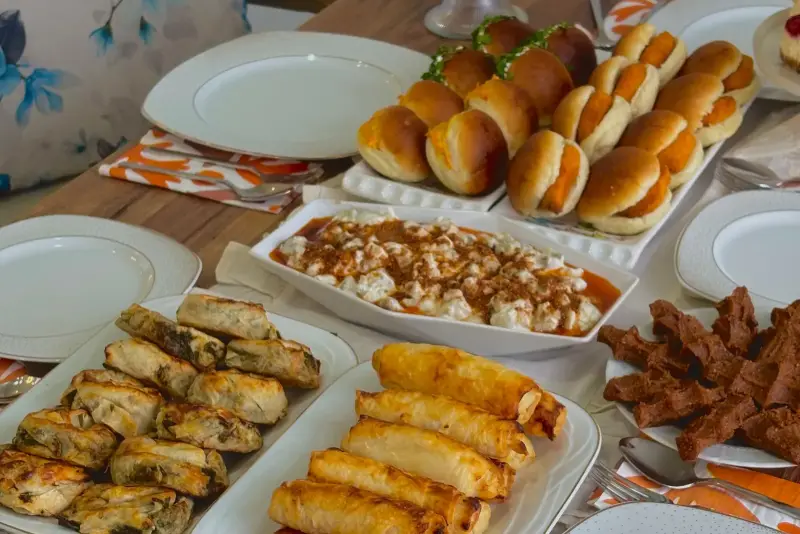 Sofraya dizilmiş ev yapımı poğaça, börek, sigara böreği ve tatlılar